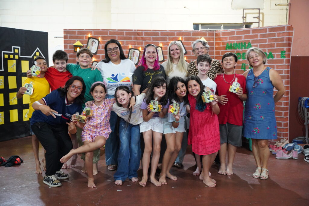 Crianças do Colégio ESCALA Bilíngue no palco da escola se divertindo em uma apresentação